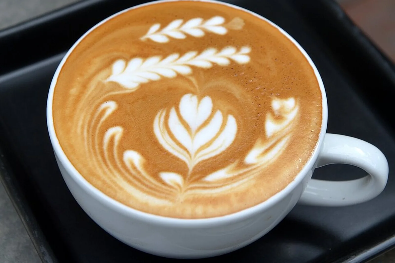 Latte on a wooden café table in Thailand