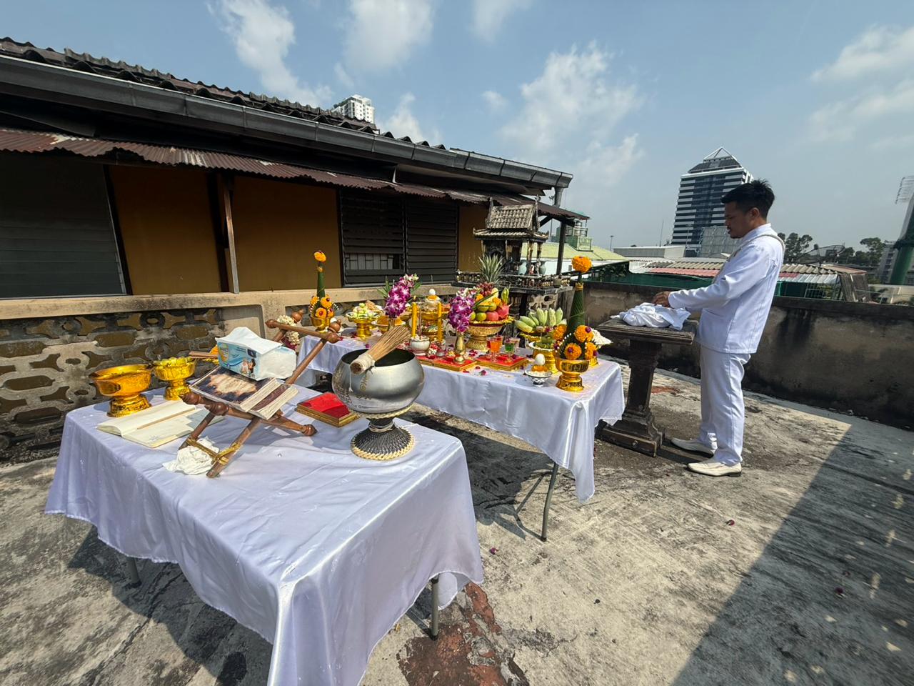 Rooftop walkway with ceremonial tables, offerings, and the city beyond before demolition began