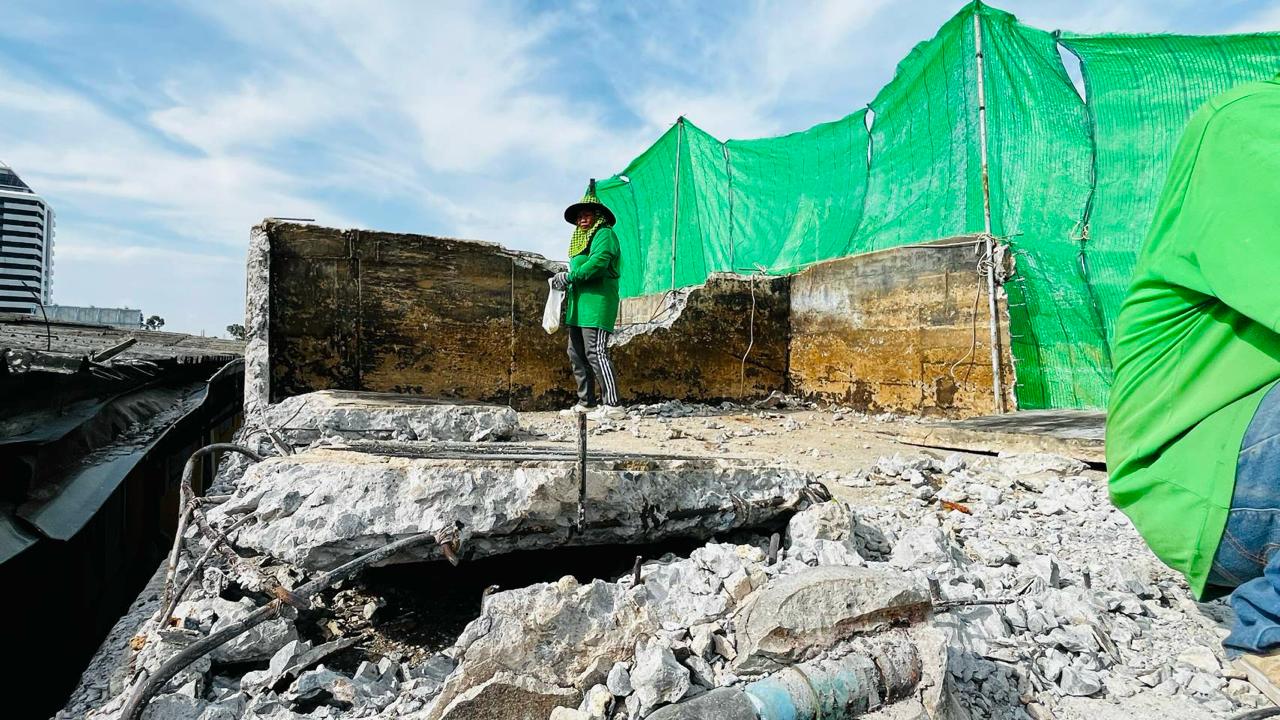 Single worker on the top floor of WITHIN surrounded by broken concrete during the first day demolition began