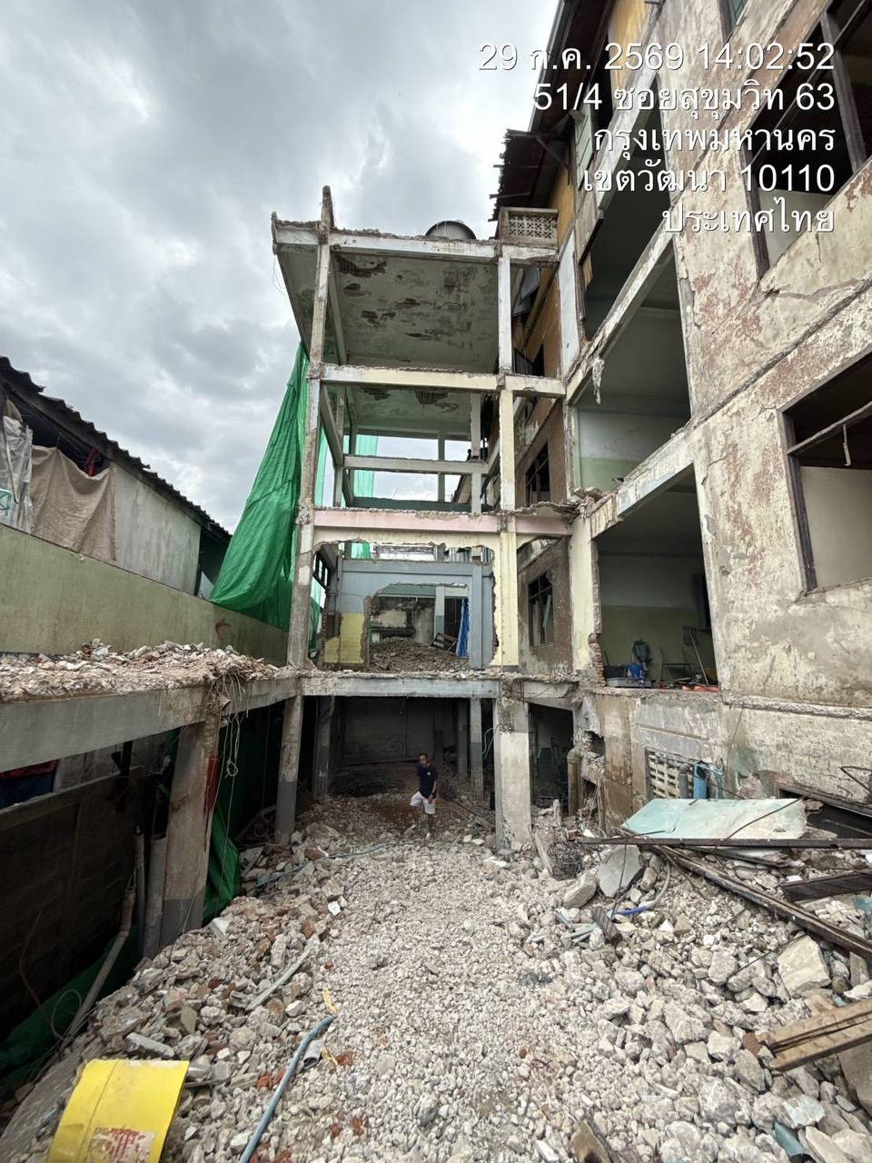 Main building demolition view at WITHIN showing the structure stripped back to ground level, heavy rubble across the site floor, and exposed concrete framing rising above