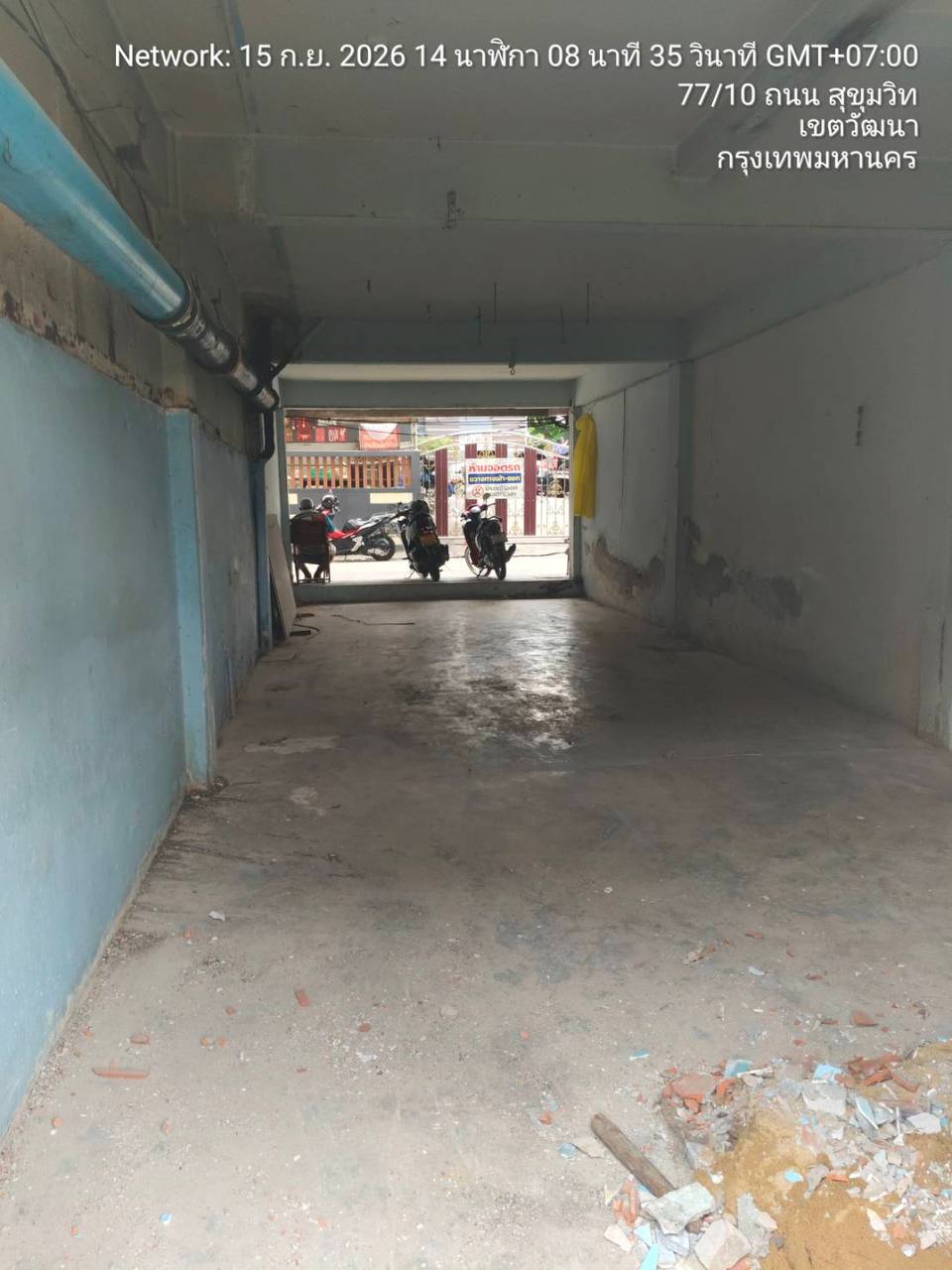 Cleared street-facing shophouse bay at WITHIN with exposed pipework and a mostly bare concrete floor