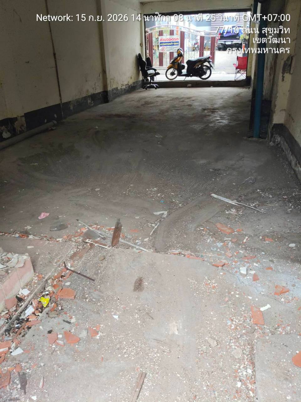 Ground-floor shophouse at WITHIN after strip-out with broken tile, masonry fragments, and rough floor transitions remaining